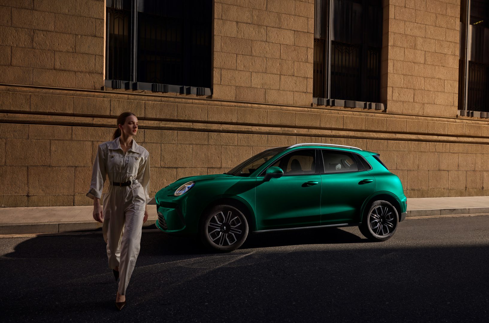 woman standing next to the green car